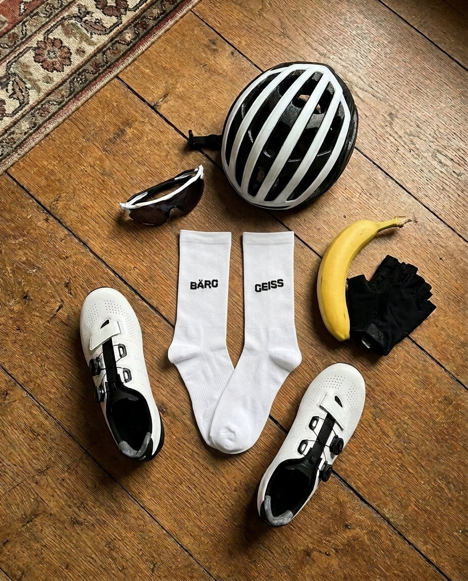 Velo-Ausrüstung mit socialride Socken Bärg Geiss auf dem Holzboden